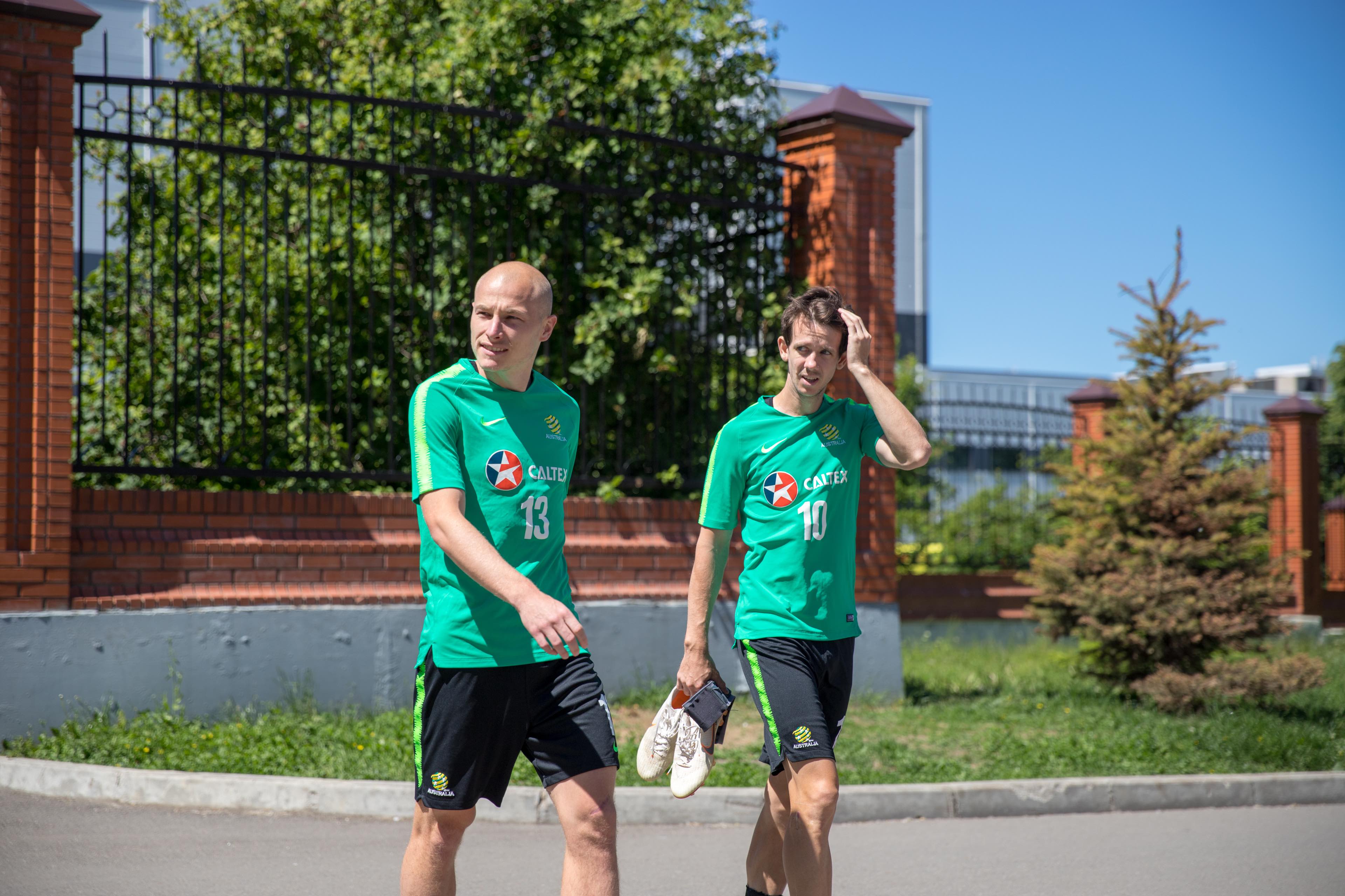 Aaron Mooy and Robbie Kruse walk to training in Kazan