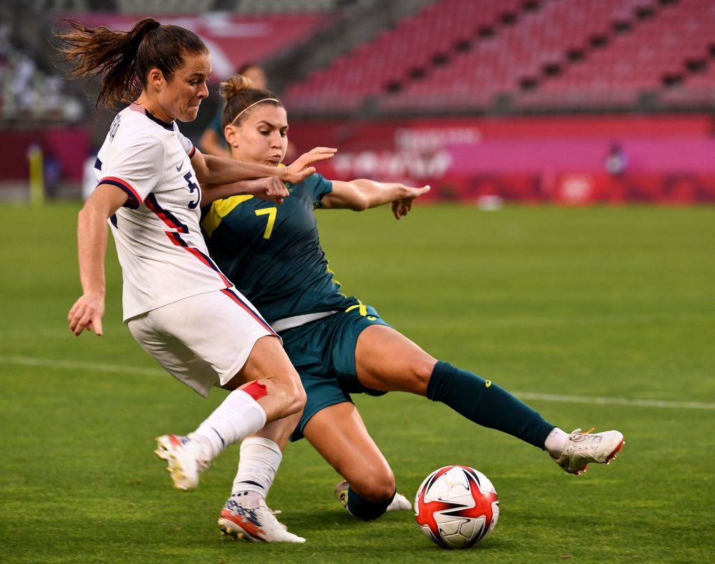 USA's defender Kelley O'Hara (L) kicks the ball while Australia's defender Steph Catley (R) attempts to block during the Tokyo 2020 Olympic Games women's group G first round football match between USA and Australia at the Ibaraki Kashima Stadium in Kashima city, Ibaraki prefecture on July 27, 2021. (Photo by SHINJI AKAGI / AFP) (Photo by SHINJI AKAGI/AFP via Getty Images)