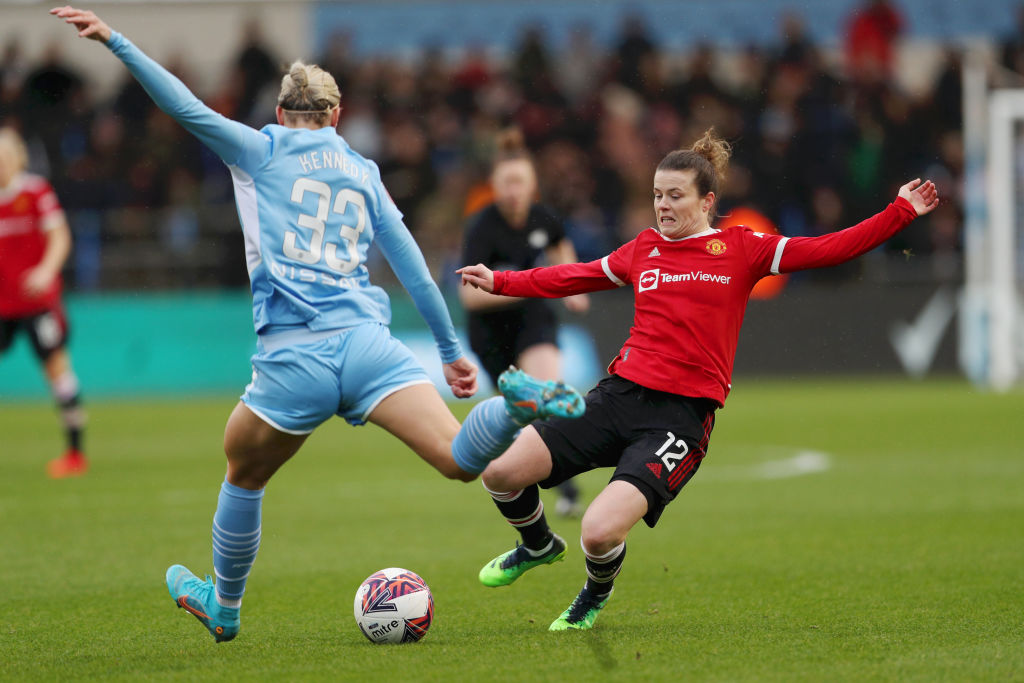 Alanna Kennedy of Manchester City is challenged by Hayley Ladd of Manchester United during the Barclays FA Women's Super League match between Manchester City Women and Manchester United Women at The Academy Stadium on February 13, 2022 in Manchester, England. (Photo by Cameron Smith/Getty Images)
