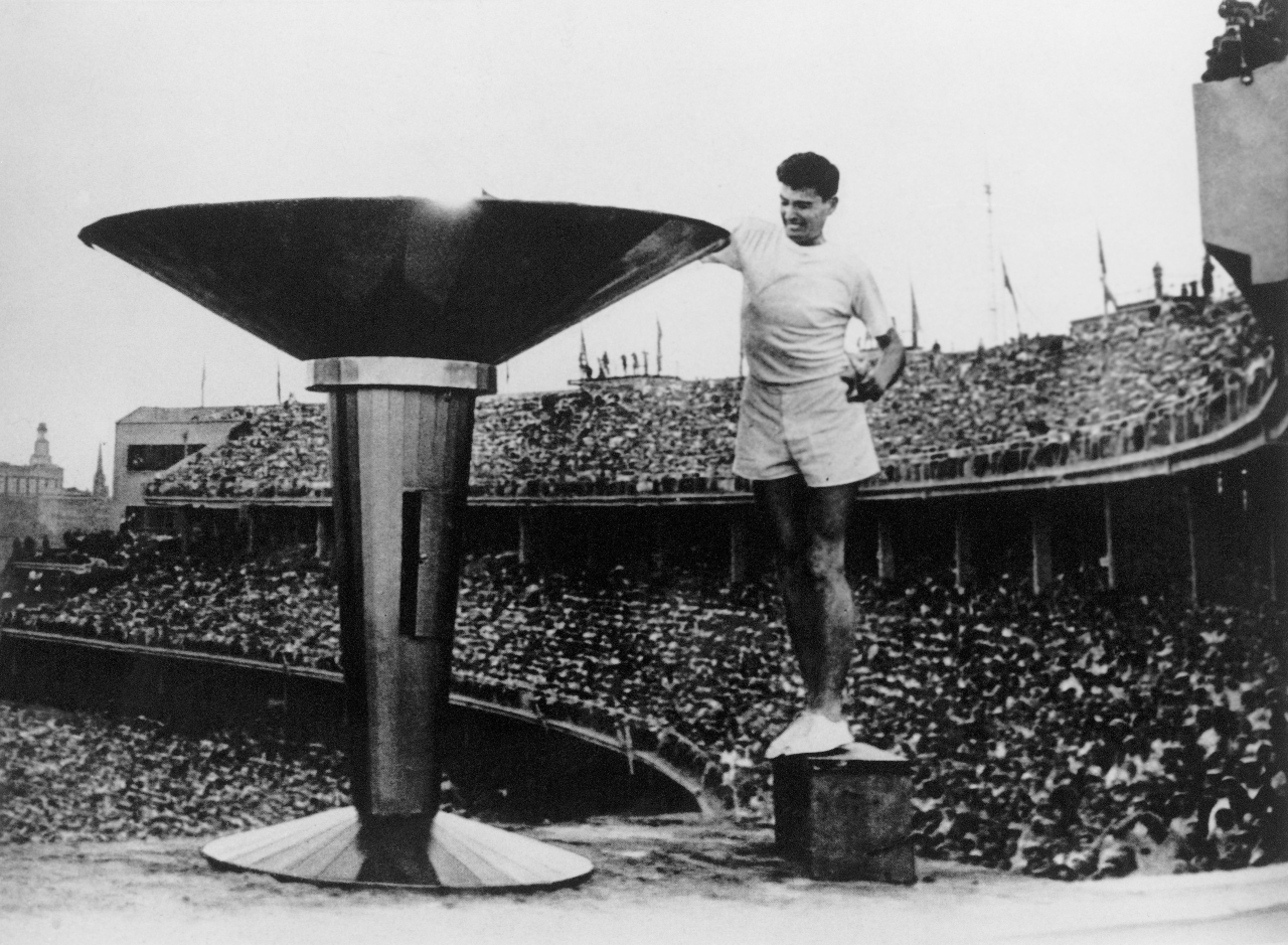 Ron Clarke lights the Olympic torch ahead of the 1956 Melbourne Games