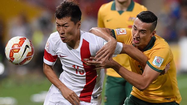 Wu Xi of China PR competes for the ball with Socceroos defender Jason Davidson.