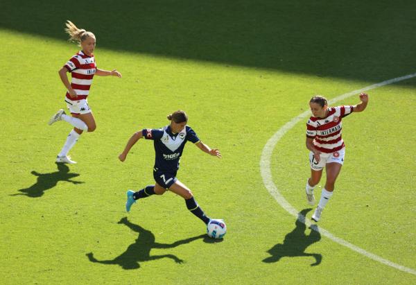 Kyra Cooney-Cross on the ball for Melbourne Victory, two Western Sydney defenders try to stop her